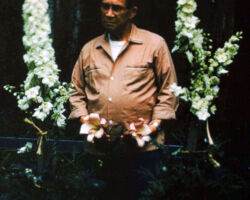 Fred Schmeeckle with delphinium and lilies from his garden. 1963.