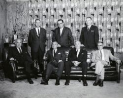 Formal photo of Conservation Commission taken at meeting in Rice Lake. Left to right: (front row) Guido R. Rahr, chairman; Charles F. Smith; Jack J. Schumacher; Paul J. Olson; (standing) James R. Smaby; John Lynch; Lester P. Voigt, Wisconsin Conservation Department director. 1961. (Photo by Dean Tvedt. Courtesy of UW-Madison Digital Archives.)