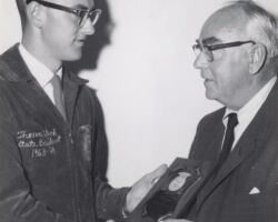 Thomas Bleck, president of the Wisconsin Association of Future Farmers of America, presents a plaque to Conservation Commission Chairman Guido Rahr for his outstanding work and interest in conservation. Mr. Bleck stated that it symbolizes the highest honor given by the Wisconsin FFA. 1964. (Photo by Staber W. Reese. Courtesy of UW-Madison Digital Archives.)