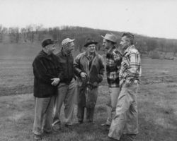 Wisconsin Conservation Department director Ernest F. Swift, talking over matters pertaining to the farm-forest-field day. L-R: Marvin Lederer; William Lesch, conservation warden; Ernest F. Swift; Ed Owen, watershed manager; and Allan Haukom, game area coordinator. 1951. Photo by Dean Tvedt. Courtesty of UW-Madison Digital Archives.