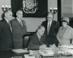 Wallace Grange (second from right) with wife Hazel looking on while Gaylord Nelson (WCHF Inductee) signs the purchase of the Sandhill Wildlife Area. 1961. Photo courtesy of Wisconsin DNR.