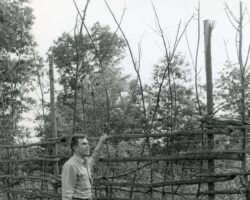 Wallace Grange at Sandhill Game Farm with deer-proof fence. 1942.