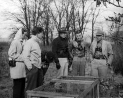 WCHF Inductee Aldo Leopold (far right) speaking to a group including Hickey (in dark jacket) at a pheasant trap in the UW-Madison Arboretum, Madison, WI. Circa mid-1940s. (Photo courtesy of Susi Hickey Nehls.)