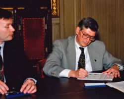 Gov. McCallum (L) observing Meyer (R) sign the document on how the DNR and EPA would work together on clean-up of the then-polluted Fox River. In the Governor’s Office, Madison, WI, 2001. (Photo courtesy of WI DNR.)