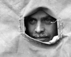 Frederick peering through a window of a Prairie Chicken blind. Every morning for about 6 weeks the Hamerstroms and their "boomers" observed Prairie Chickens on their booming grounds. (Photo by Hugh Wilmar.)